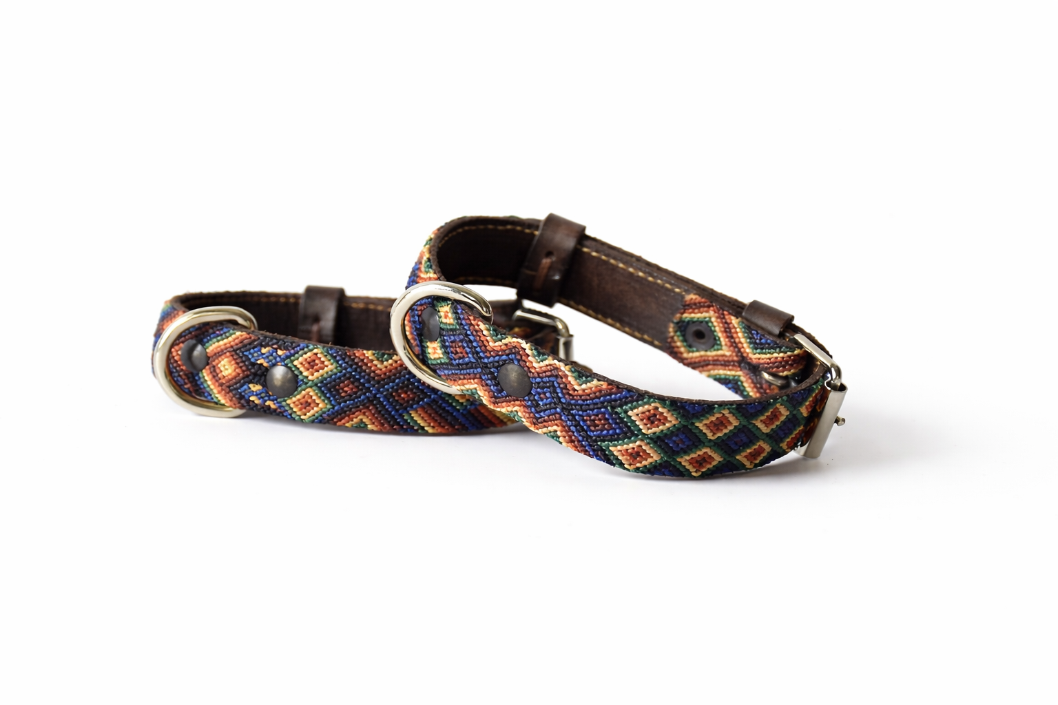 A woven dog collar with a dark brown leather strap and silver-tone metal hardware, featuring a colorful geometric diamond pattern in blue, red, yellow, and white.