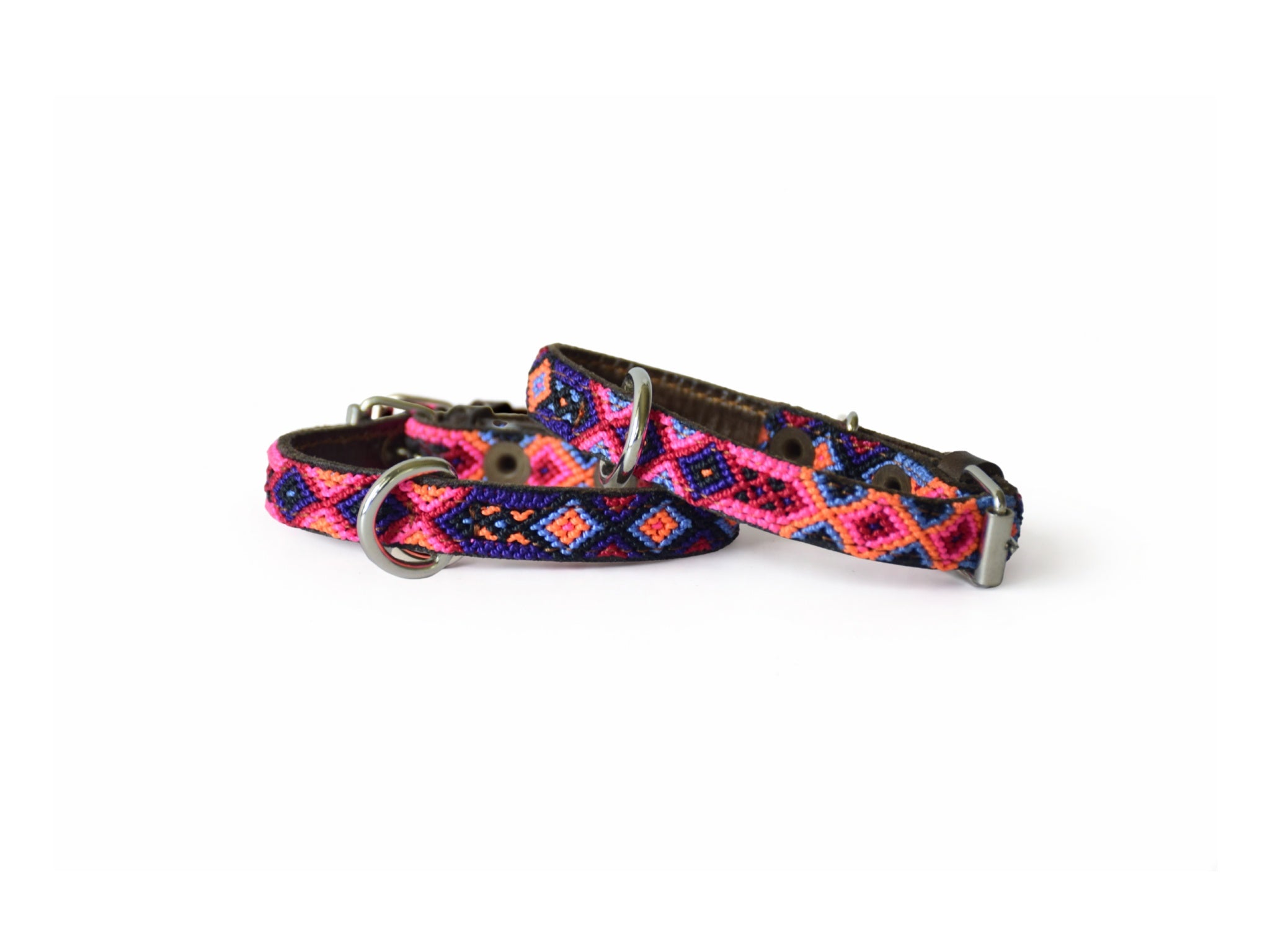 A woven dog collar with a colorful geometric pattern in pink, blue, and orange, featuring silver-tone metal hardware, shown on a plain white background.