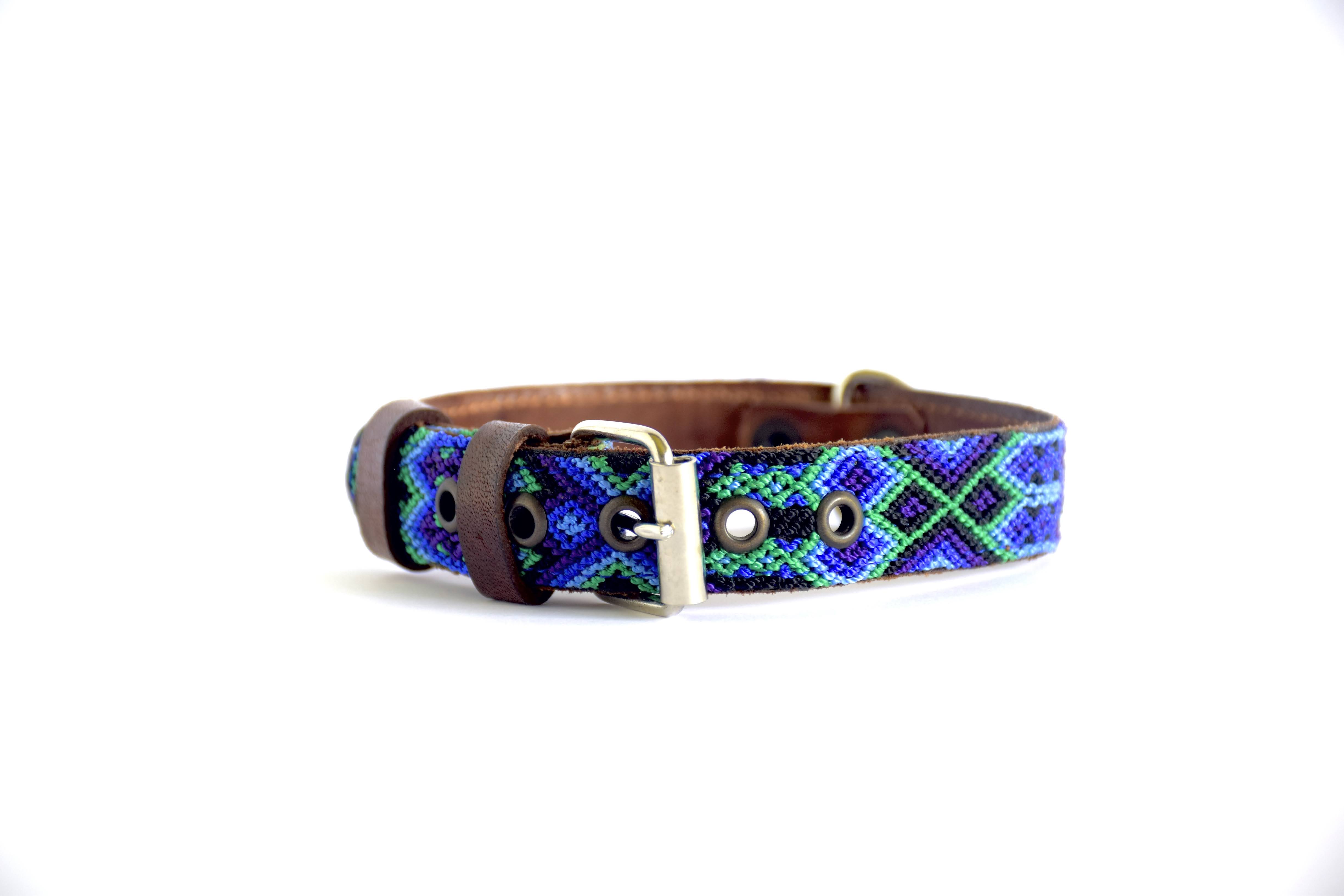 A woven leather belt with a geometric pattern in blue, green, and purple, featuring a brown leather strap and a silver-tone metal buckle.